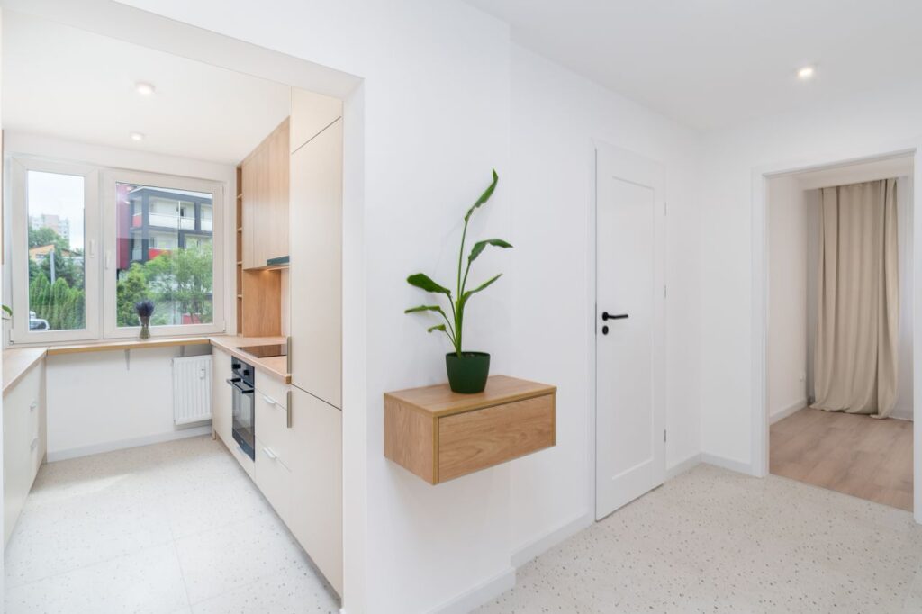 Bright and minimalist kitchen and hallway in a modern Kraków apartment.